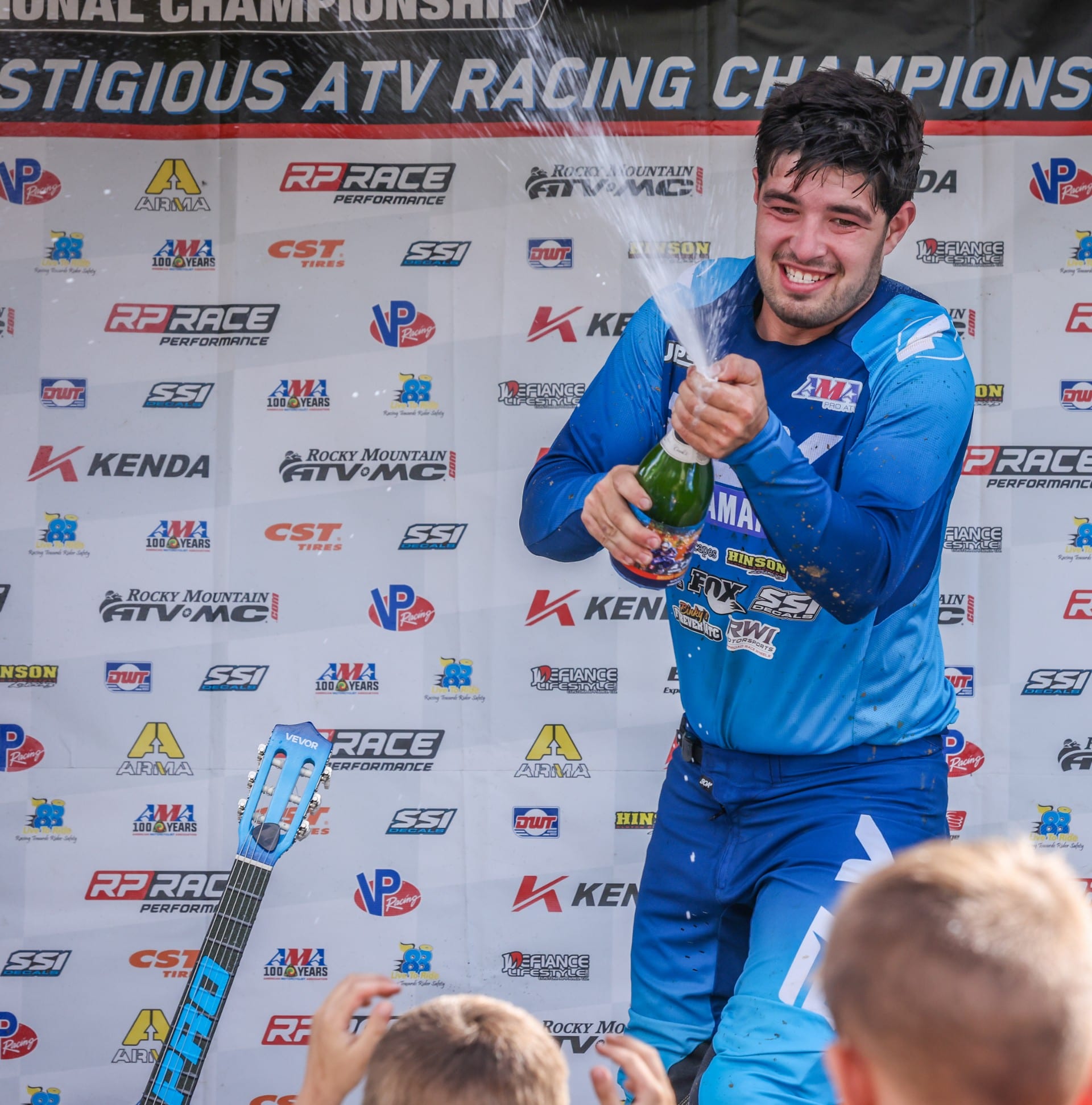 RWI athlete spraying champagne on the podium — ATV racing championship win
