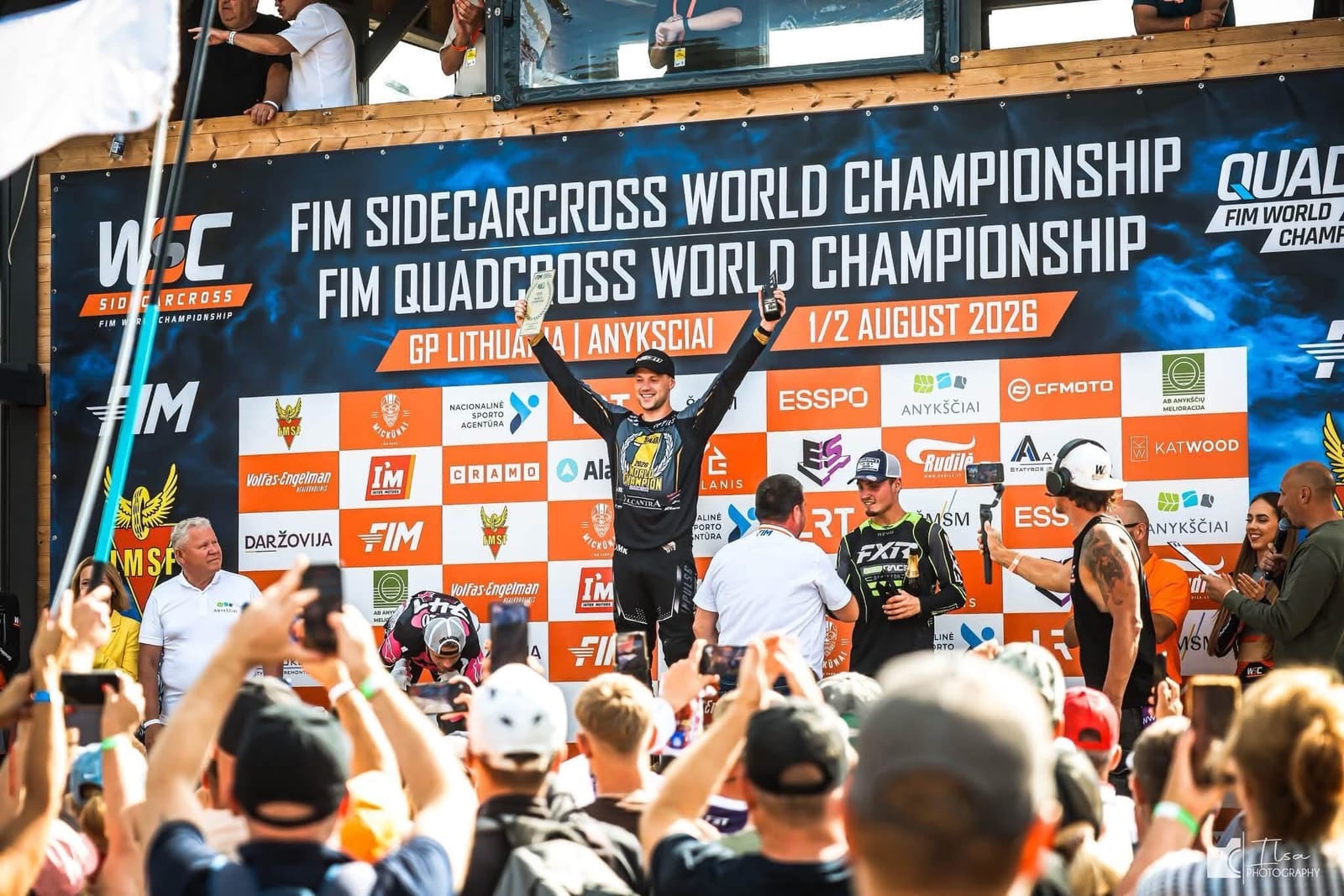 Kevin Saar on the top step with his arms raised beneath the FIM Quadcross World Championship banner